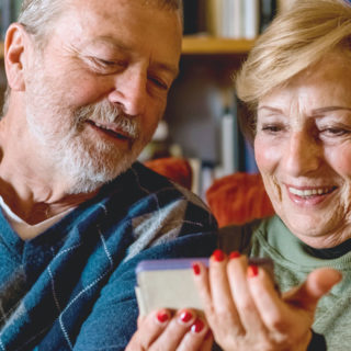Photo of elderly couple using phone